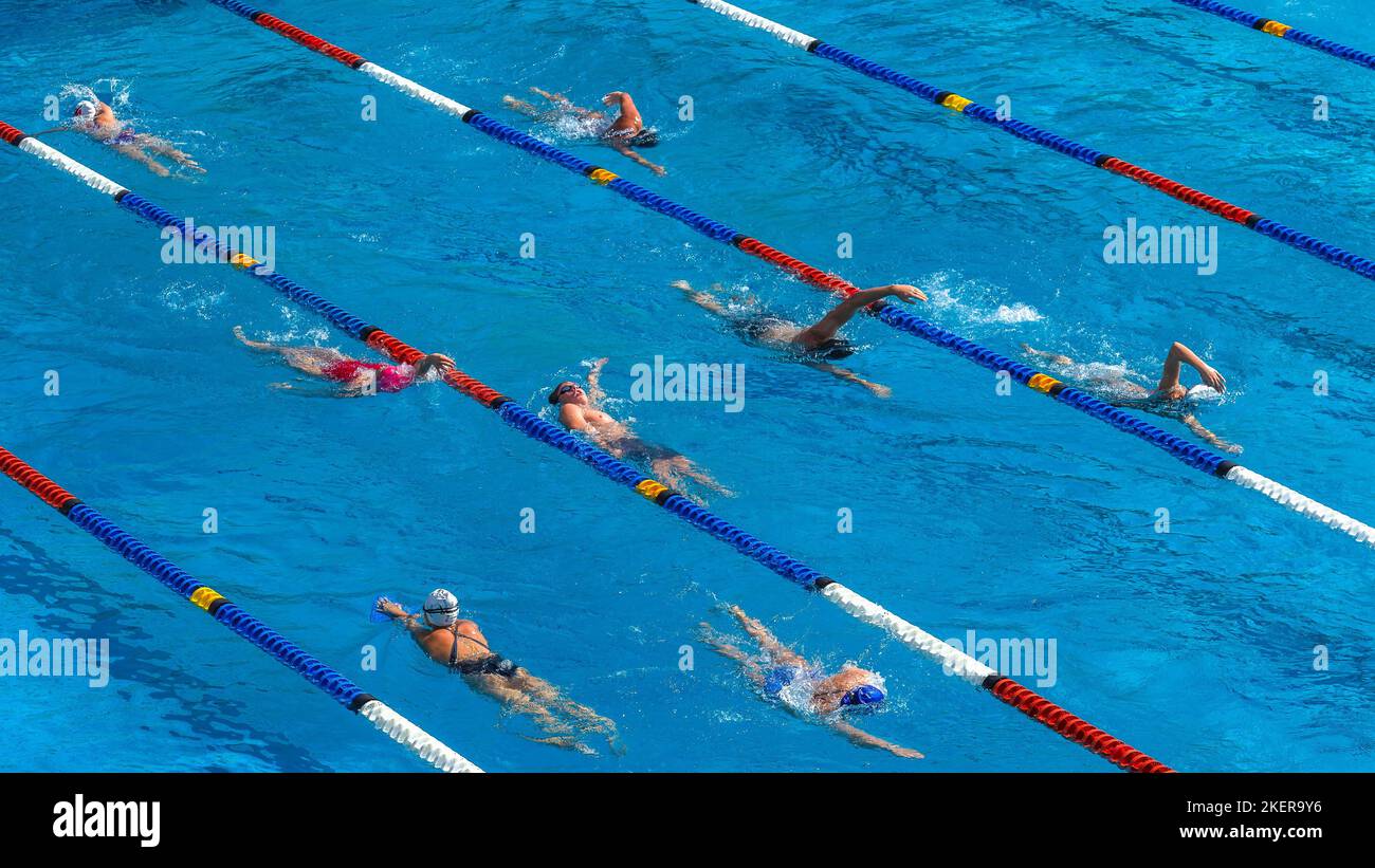 Nuotatori atleti irriconoscibile maschile e femminile esercizio di allenamento in corsie di marcatura foto sopra la piscina all'aperto paesaggio. Foto Stock