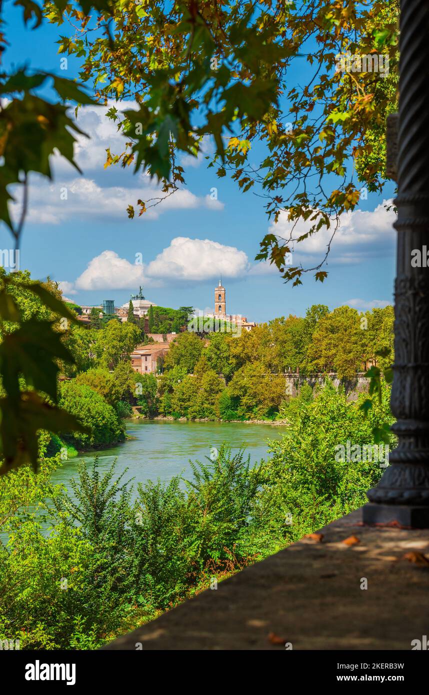 Natura a Roma. Vista del centro storico della città con la torre del Campidoglio dal lungofiume del Tevere, ricca di alberi Foto Stock