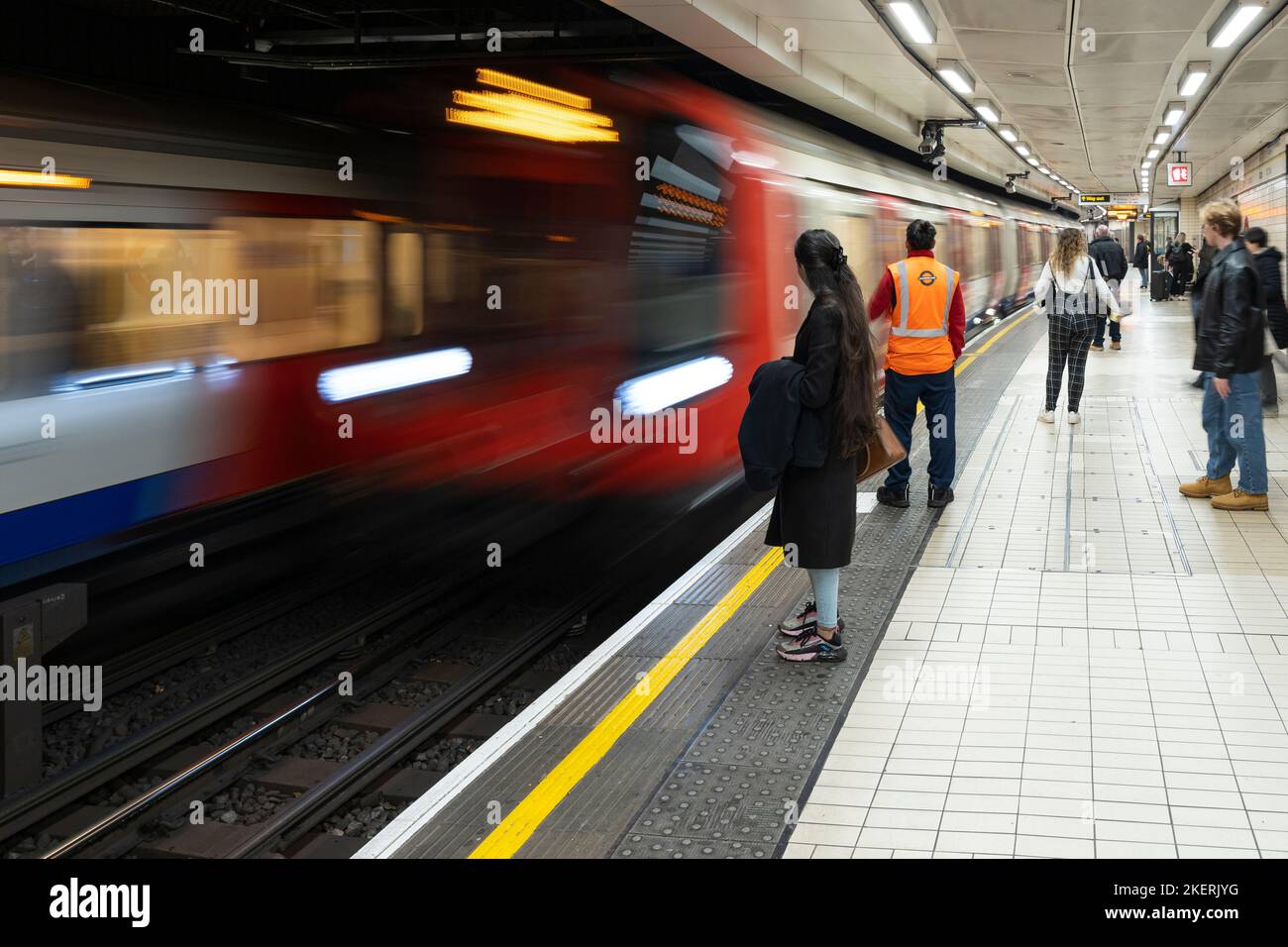 I passeggeri in attesa di un treno della metropolitana che arriva alla stazione Victoria sulla Circle Line. Londra, Inghilterra. Tema: Sciopero della metropolitana, autisti della metropolitana, TFL Foto Stock
