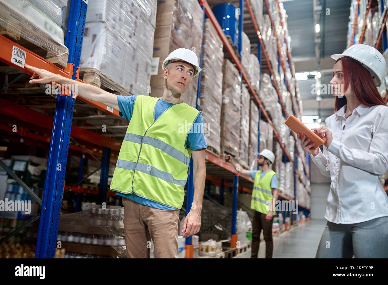 I dipendenti del magazzino che eseguono un'ispezione dell'impianto di scaffalatura Foto Stock