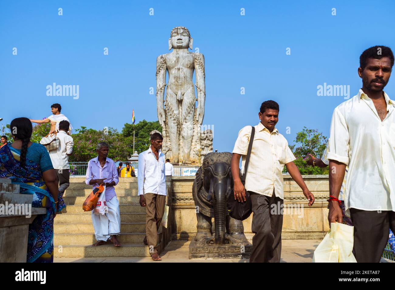 Dharmasthala, Karnataka, India : i pellegrini camminano accanto alla statua monolitica alta 12 m di Bahubali (Gomateshwara) a Ratnagiri Hill. Un fi molto venerato Foto Stock