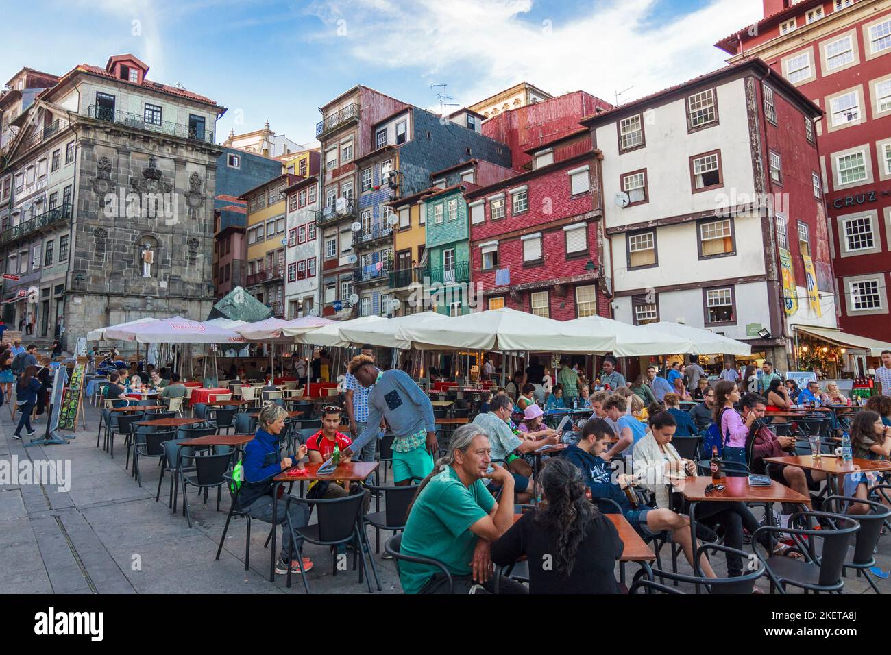 Porto, Portogallo - 26th luglio 2018 : la gente siede in un caffè all'aperto nel quartiere di Ribeira, patrimonio dell'umanità dell'UNESCO. Foto Stock