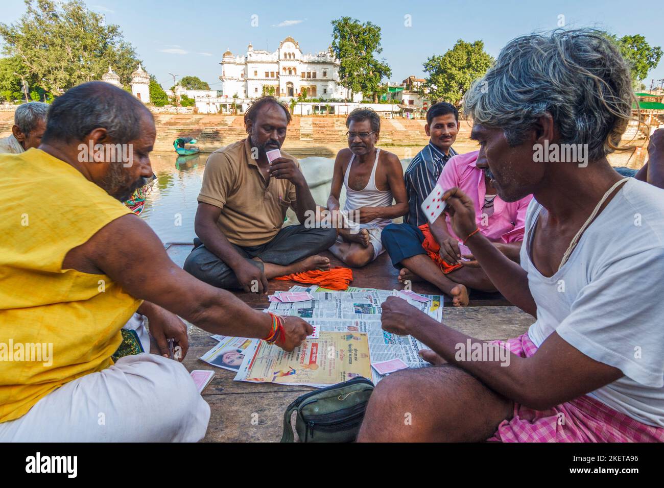 Chitrakoot, Madhya Pradesh, India : Un gruppo di uomini gioca le carte sui gradini di Ramghat sul fiume Mandakini. Foto Stock