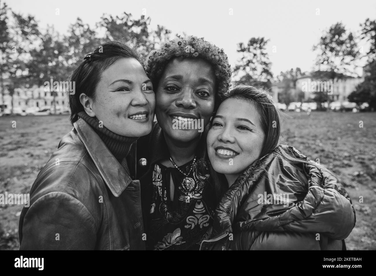 Ritratto in bianco e nero di tre donne mature sorridenti all'aperto, concetto di amicizia e diversità Foto Stock