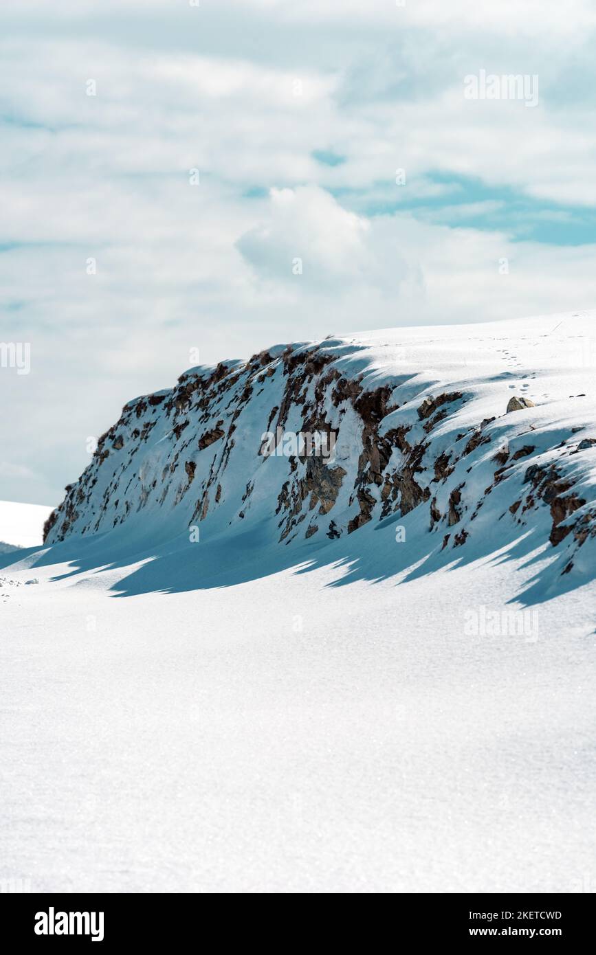 Paesaggio invernale, collina di montagna ricoperta di neve bianca pura con cielo blu sullo sfondo Foto Stock