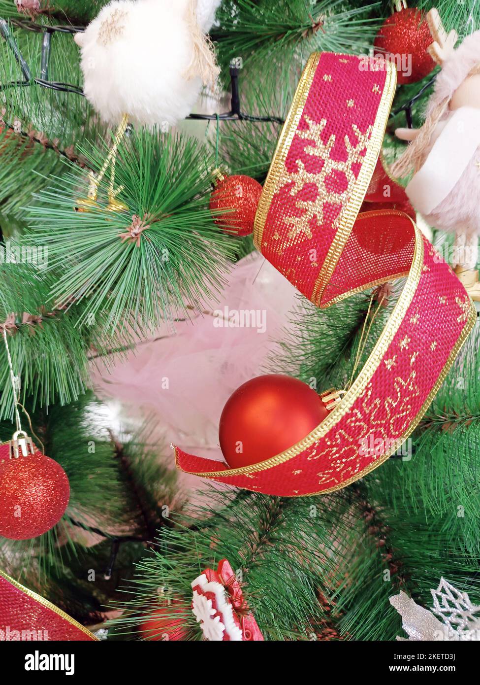 Decorazioni natalizie appese all'albero verde, materiale sintetico, cultura italiana. Foto Stock