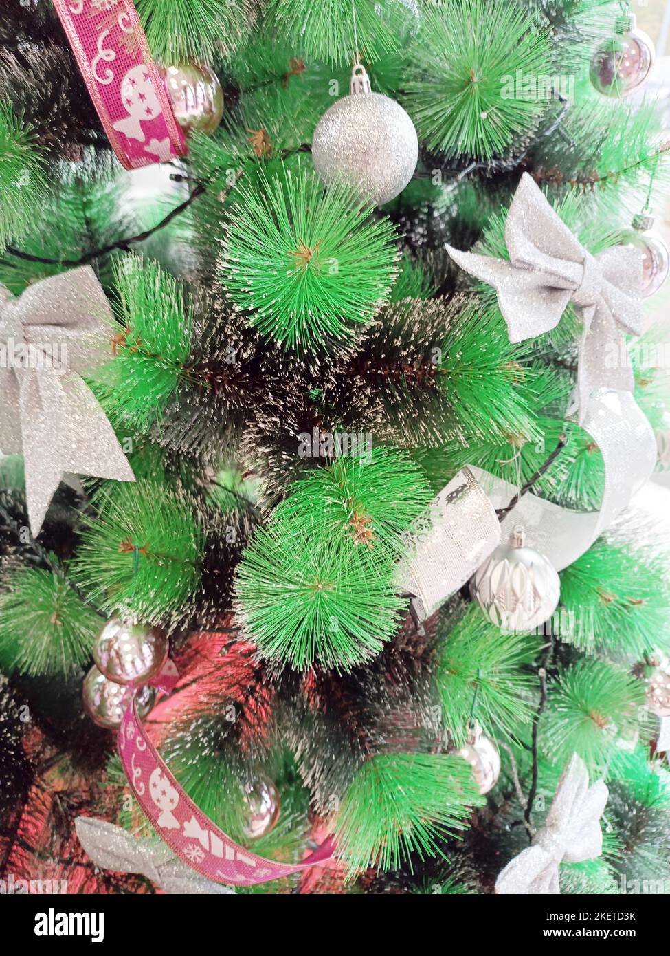 Decorazioni natalizie appese all'albero verde, materiale sintetico, cultura italiana. Foto Stock