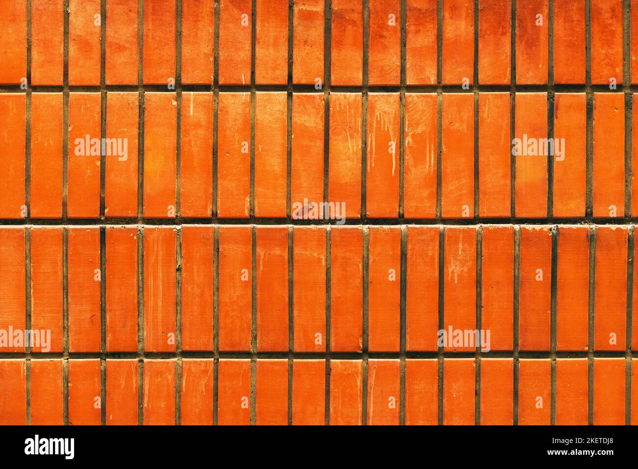 Muro di mattoni arancione sporco come struttura urbana e sfondo con macchie Foto Stock