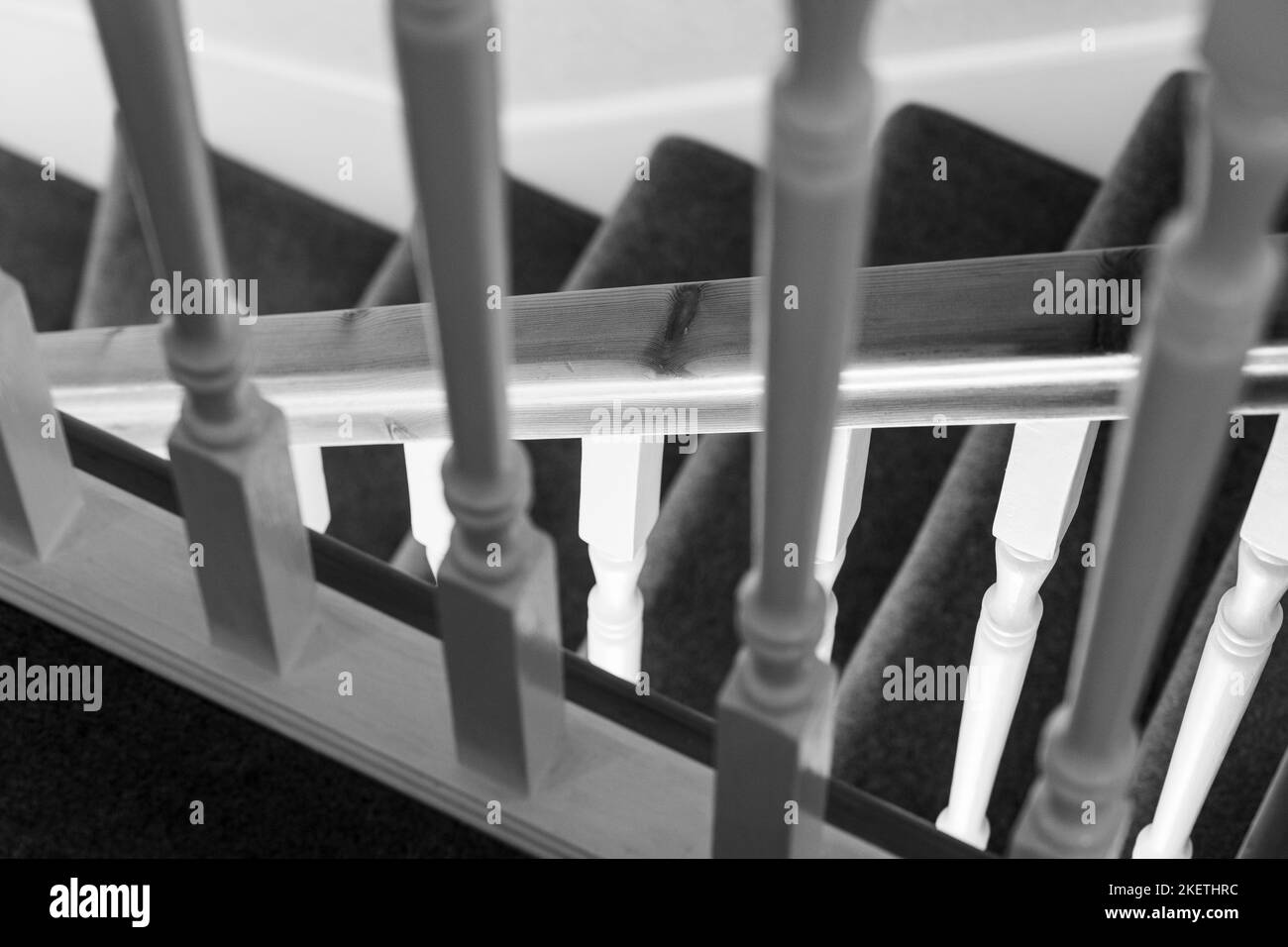Prospettiva interessante e insolita guardando attraverso le banistere di atterraggio giù per le scale che scendono in una casa del Regno Unito Foto Stock