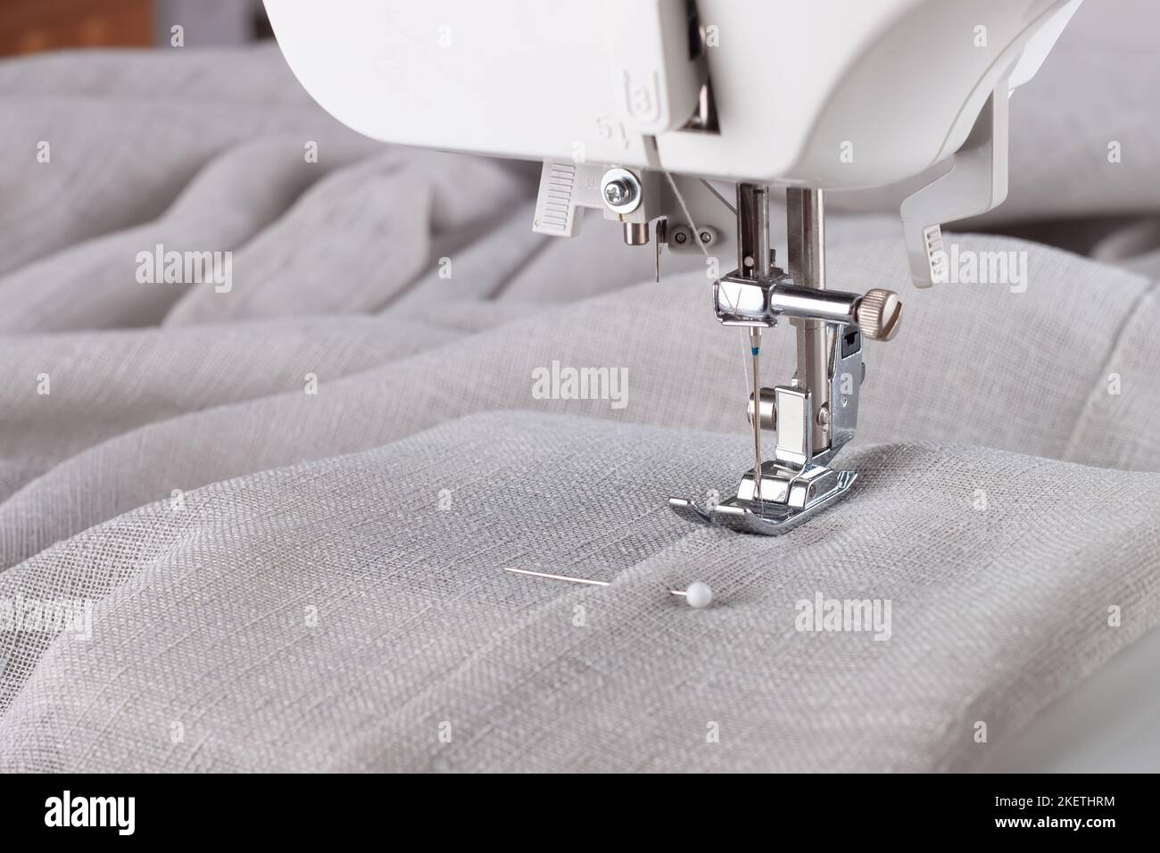 Moderno piedino pressatore per macchina da cucire con tessuto e filo di lino, primo piano, spazio copia. Cucire abiti, tende, tappezzeria. Affari, hobby, h Foto Stock