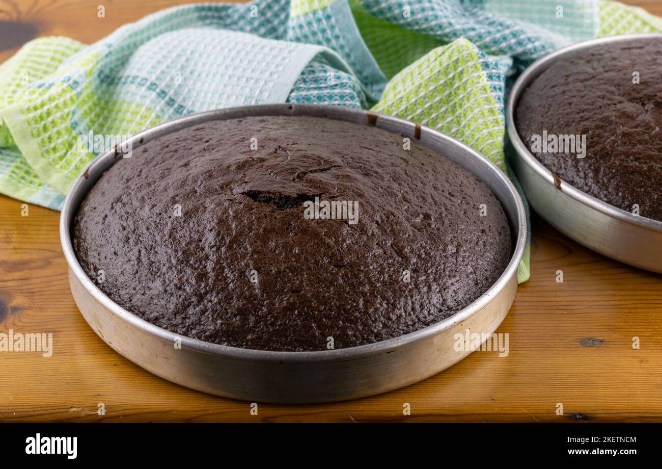 Torte al cioccolato non gelate in padelle su tavolo di legno - fuoco selettivo Foto Stock