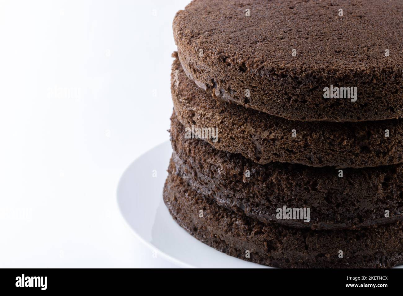 Strati di torta al cioccolato non smerigliata isolati su bianco con spazio di copia Foto Stock