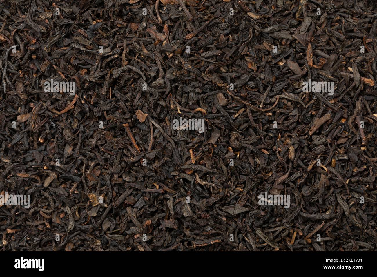 Il tè essiccato cinese di Keemun lascia la cornice completa di primo piano come sfondo Foto Stock