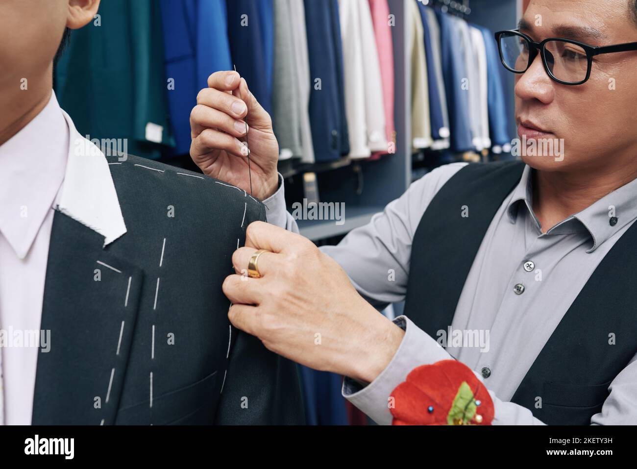 Manica da cucire su misura asiatica professionale sulla giacca Foto Stock