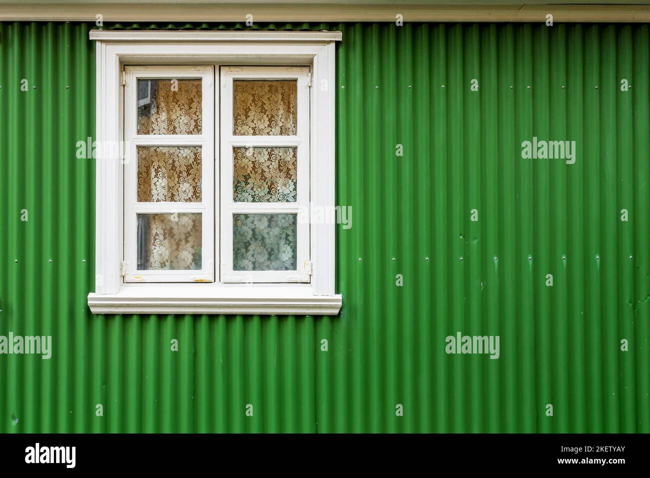 Finestra su un muro dipinto di verde, casa colorata, dettaglio architettonico a Reykjavik, Islanda Foto Stock