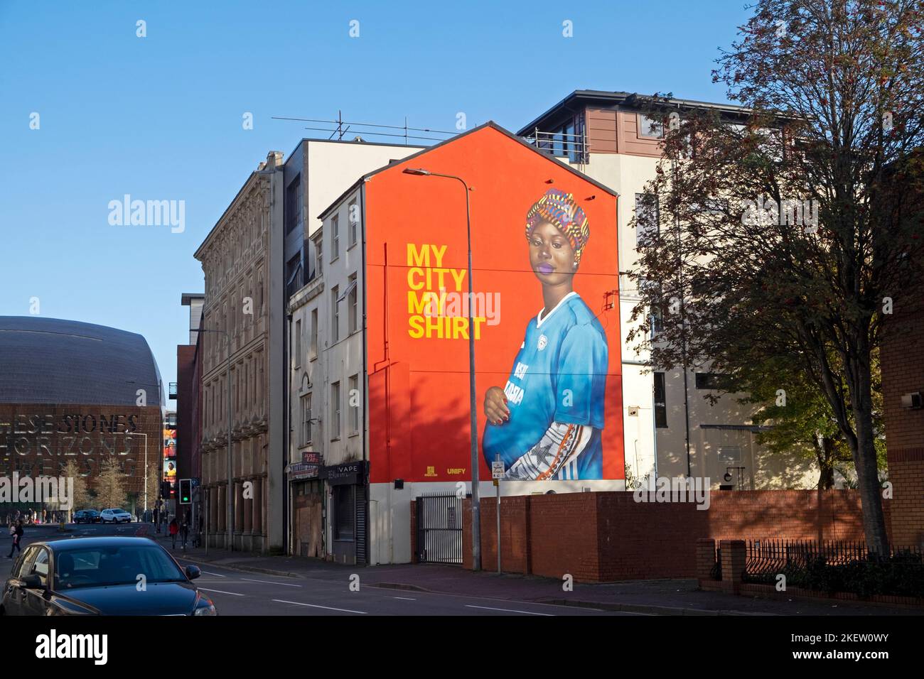 'My City My Shirt' murale donna gallese africana incinta che indossa una maglia da calcio Butetown Cardiff Bay area Galles Regno Unito Gran Bretagna KATHY DEWITT Foto Stock