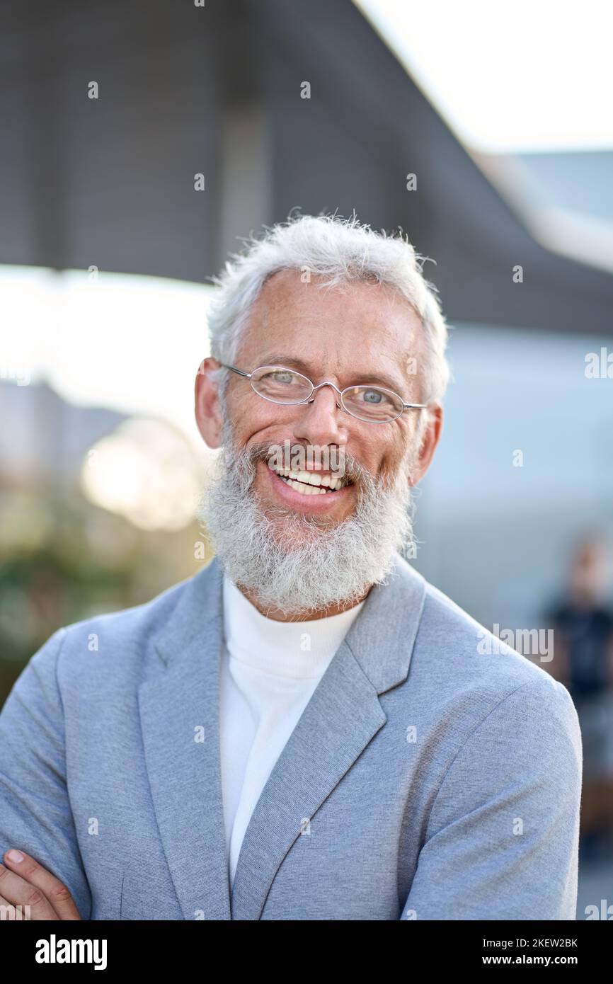 Sorridente uomo d'affari anziano maturo felice all'aperto, ritratto verticale con foto alla testa. Foto Stock