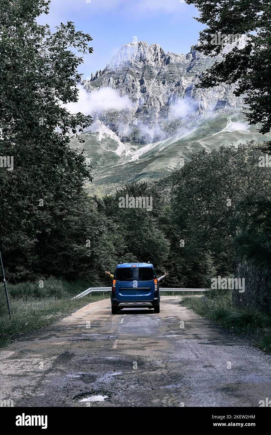 piccolo furgone che guida lungo una strada stretta e solitaria con una mano che sporge dal finestrino sinistro e l'altra mano che sporge dal finestrino destro, ruta del Foto Stock