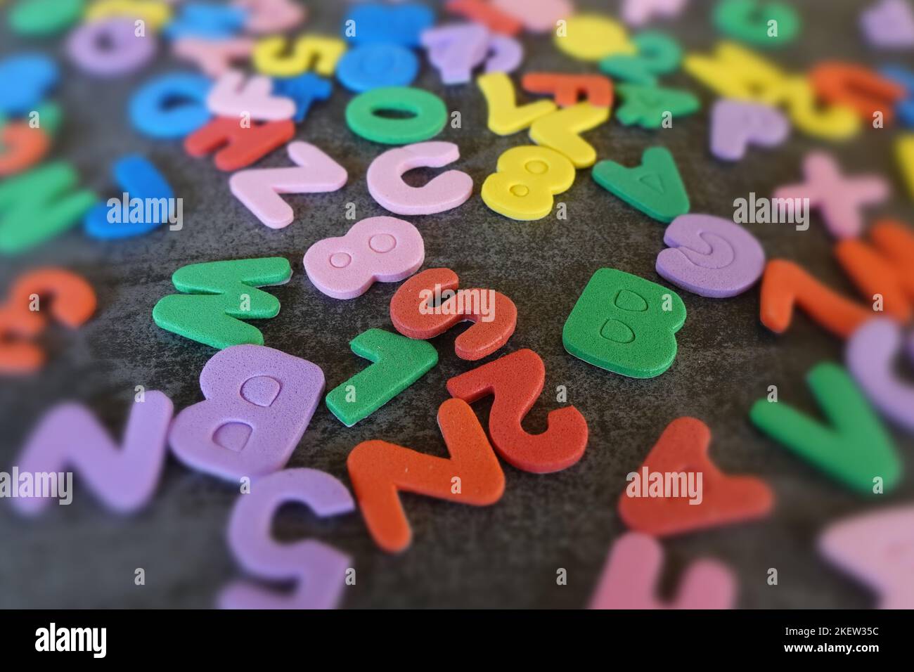 Lettere dell'alfabeto dei bambini caratteri colorati di tipo ritagliato. Astratto sfocatura formazione prescolare. Foto Stock