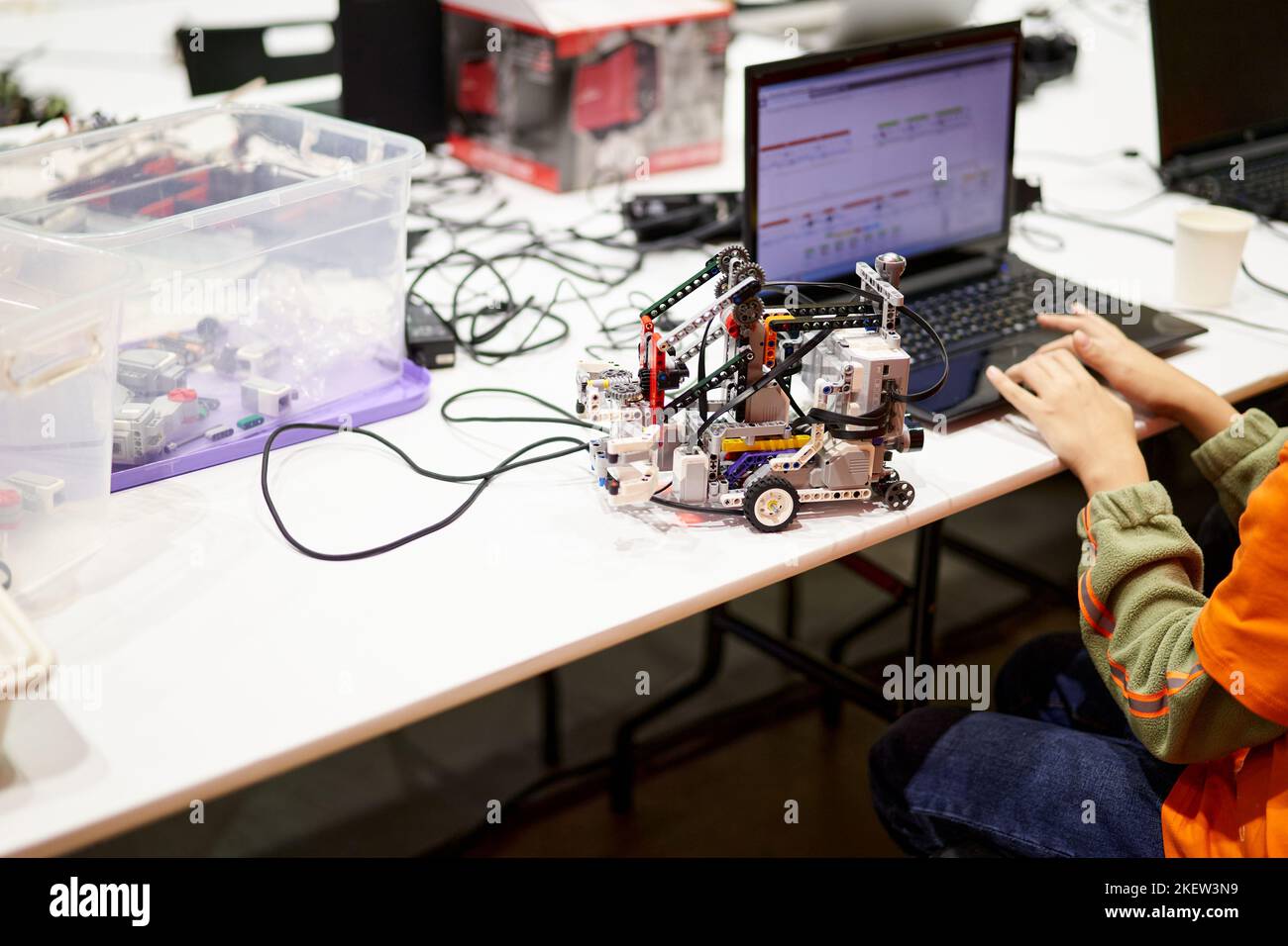Le mani di uno studente, di uno studente, di costruire veicoli robotici, di automobili robotiche, utilizzavano applicazioni software didattiche per computer. Un bambino che studia programmazione è seduto a un tavolo in una lezione di programmazione di INGEGNERIA A VAPORE. Foto Stock
