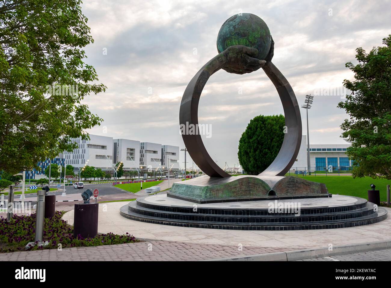 Le mani che si alzano da un libro sostengono il globo in questa scultura all'Aspire Academy del Qatar a Doha. Foto Stock