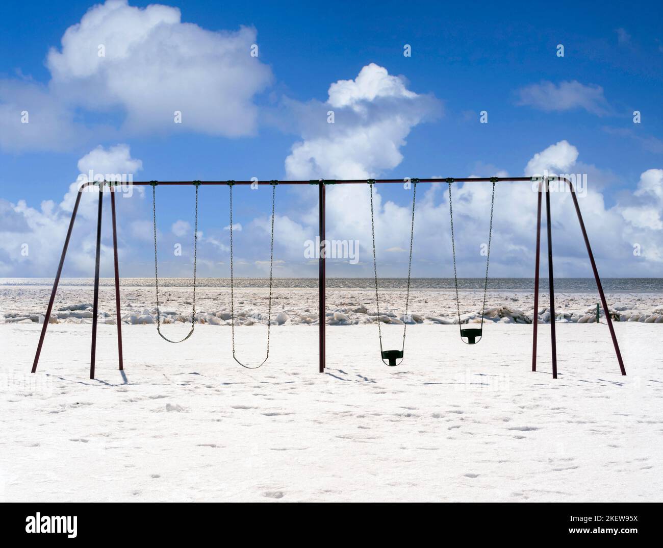 Swingset in un parco giochi lungo una costa ghiacciata dell'Atlantico. Foto Stock