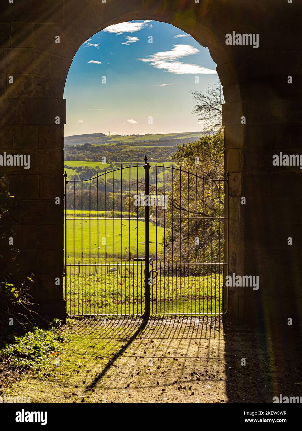 Guardando fuori attraverso uno degli archi dell'Archer's Hill Gate verso il parco dei Giardini del Castello di Wentworth. REGNO UNITO Foto Stock