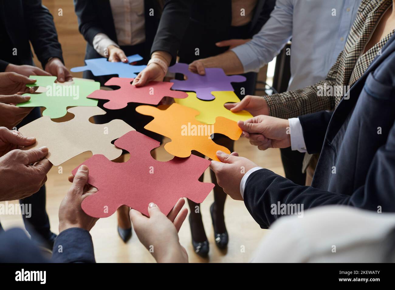 Team aziendale che suggerisce idee creative e collegare pezzi colorati di puzzle Foto Stock