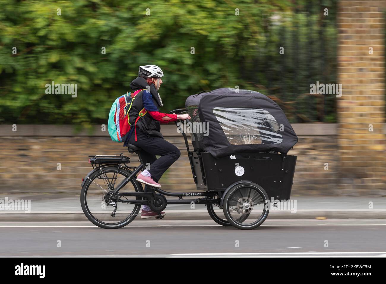 Una donna che pedala una bicicletta e-cargo, lungo Waterloo Raod, Londra, Regno Unito. 16 Ott 2022 Foto Stock