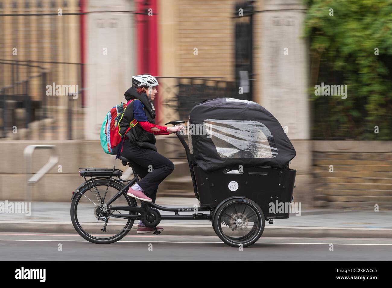 Una donna che pedala una bicicletta e-cargo, lungo Waterloo Raod, Londra, Regno Unito. 16 Ott 2022 Foto Stock