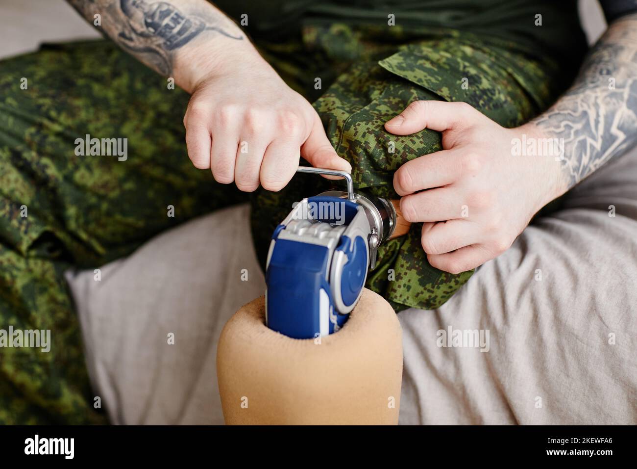 Primo piano del veterano militare che fissa la gamba protesica, copia spazio Foto Stock