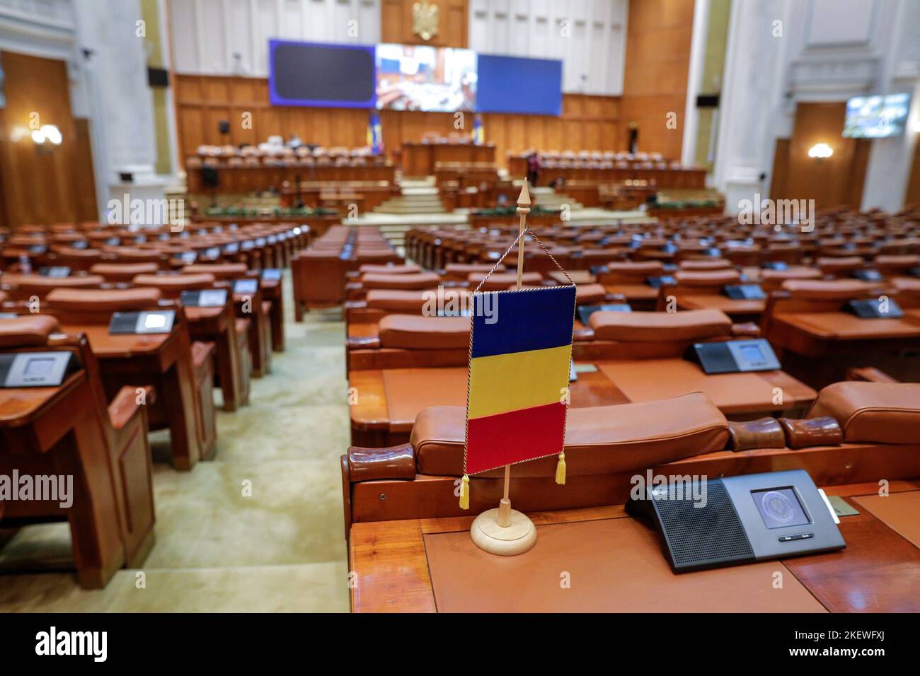 Bucarest, Romania - 14 novembre 2022: Bandiera rumena e posti vuoti nella Camera dei deputati rumena all'interno del Palazzo del Parlamento. Foto Stock