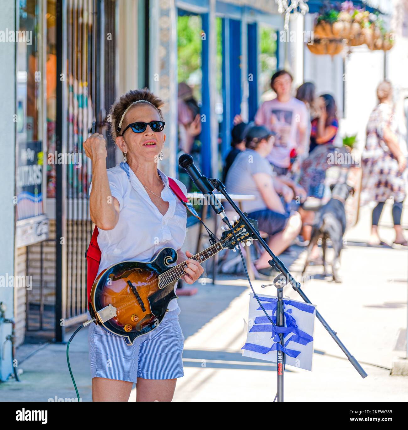 NEW ORLEANS, LA, USA - 12 GIUGNO 2020: Focus selettivo di Valerie Sassyfras che bussando con il suo mandolino su Oak Street e le persone sullo sfondo Foto Stock