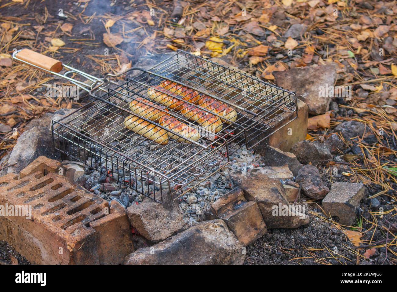 Salsicce alla griglia. Carne alla griglia. Kebab arrosto. Cibo alla griglia. Salsicce affumicate all'aperto. Cucina fritta. Concetto di campeggio. Delizioso barbecue Foto Stock