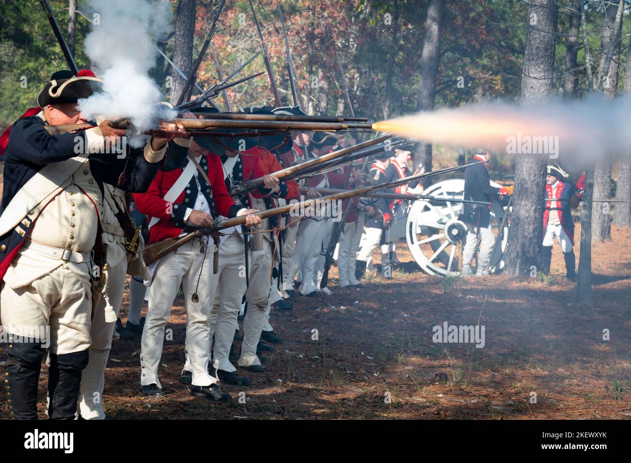 Kershaw, Carolina del Sud, Stati Uniti. 13th Nov 2022. Gli appassionati della guerra rivoluzionaria e gli appassionati re-attori ricreano la Battaglia di Camden, SC, consentendo ai visitatori di vivere la storia durante la guerra per l'indipendenza dal dominio britannico. La battaglia di Camden, combattuta nel 1780, fu una delle numerose devastanti sconfitte subite dagli americani nelle prime fasi dell'offensiva militare britannica nel Sud. Nella foto: I soldati britannici sparano le loro musche mentre un equipaggio canon si prepara a sparare tondi. (Credit Image: © Robin Rayne/ZUMA Press Wire) Foto Stock