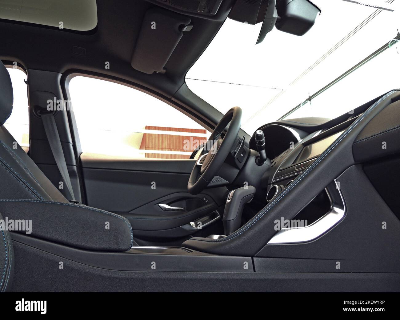 Sedili anteriori rivestiti in alcantara nero con cuciture filettate blu negli interni dell'auto Foto Stock