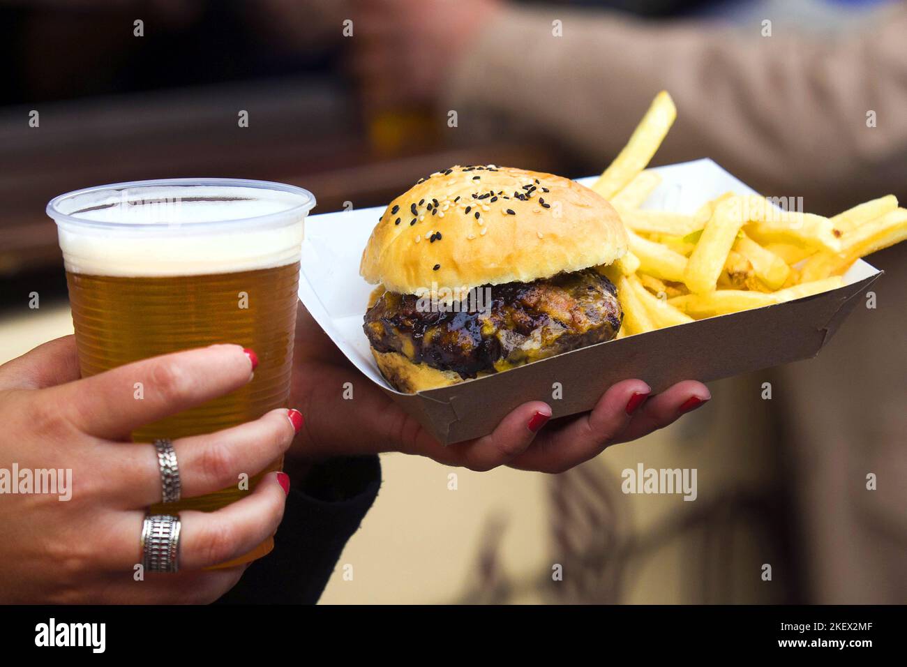 Bicchiere di birra bionda artigianale e hamburger con patatine fritte Foto Stock