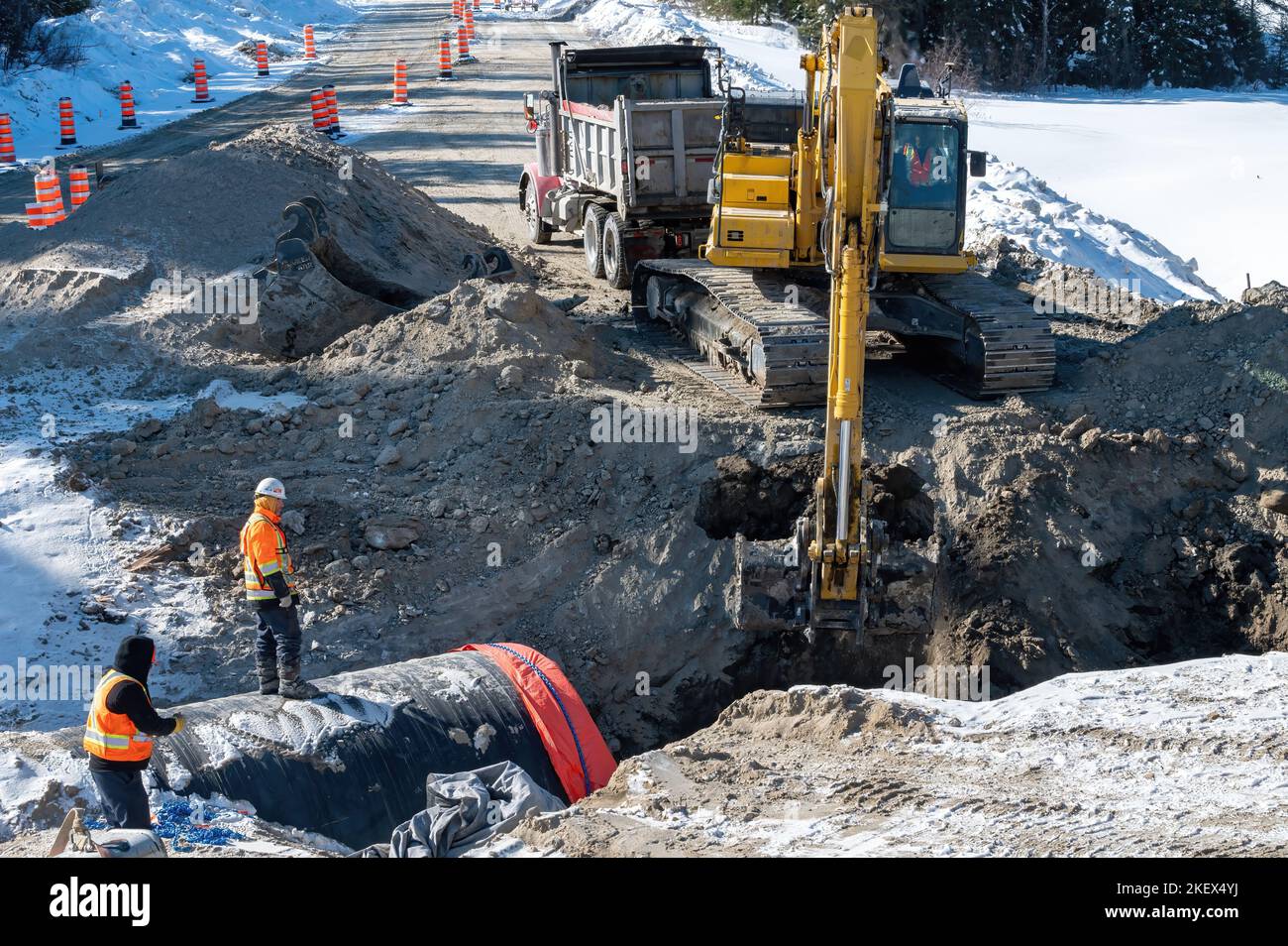 Lavori di scavo per la sostituzione di un fognolo su strada durante l'inverno Foto Stock