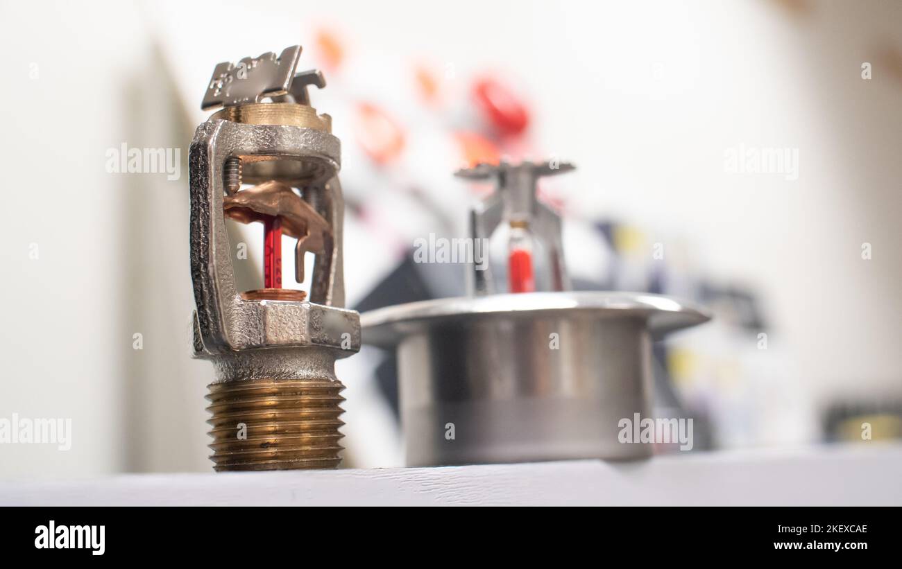 Testine sprinkler antincendio con collegamenti fusibili e lampadine frangibili. Foto Stock