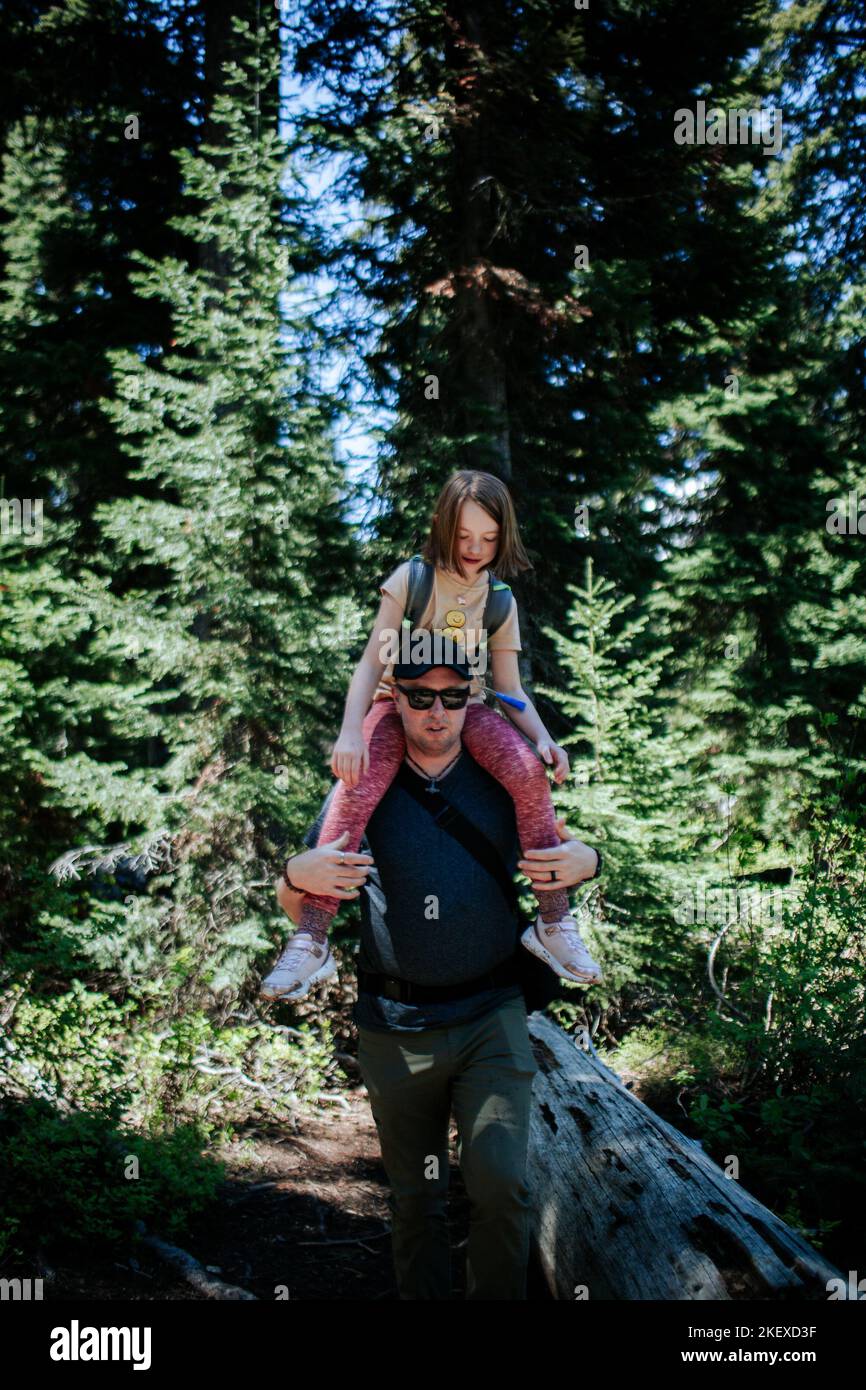 Padre che porta la giovane figlia sulle spalle durante un'escursione Foto Stock