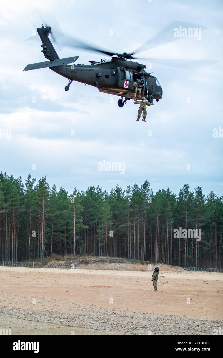 Soldati statunitensi assegnati a Bravo Battery, Death Dealers, 2nd battaglione, 174th Air Defense Artillery Regiment (2-174 ADA) operativamente controllati da 1st Divisione di Fanteria (1 ID), conduce l'addestramento al funzionamento dell'argano durante l'esercizio di addestramento sul campo degli incontri ravvicinati a Camp Ādaži, Lettonia, 9 novembre 2022. L’ADA del 2-174 sta lavorando con orgoglio, tra le altre unità, insieme all’ID del 1, agli alleati della NATO e ai partner della sicurezza regionale per fornire forze credibili dal combattimento al V Corps, il corpo americano schierato in futuro in Europa. (STATI UNITI Foto della Guardia Nazionale militare di SPC. Ancheta) Foto Stock