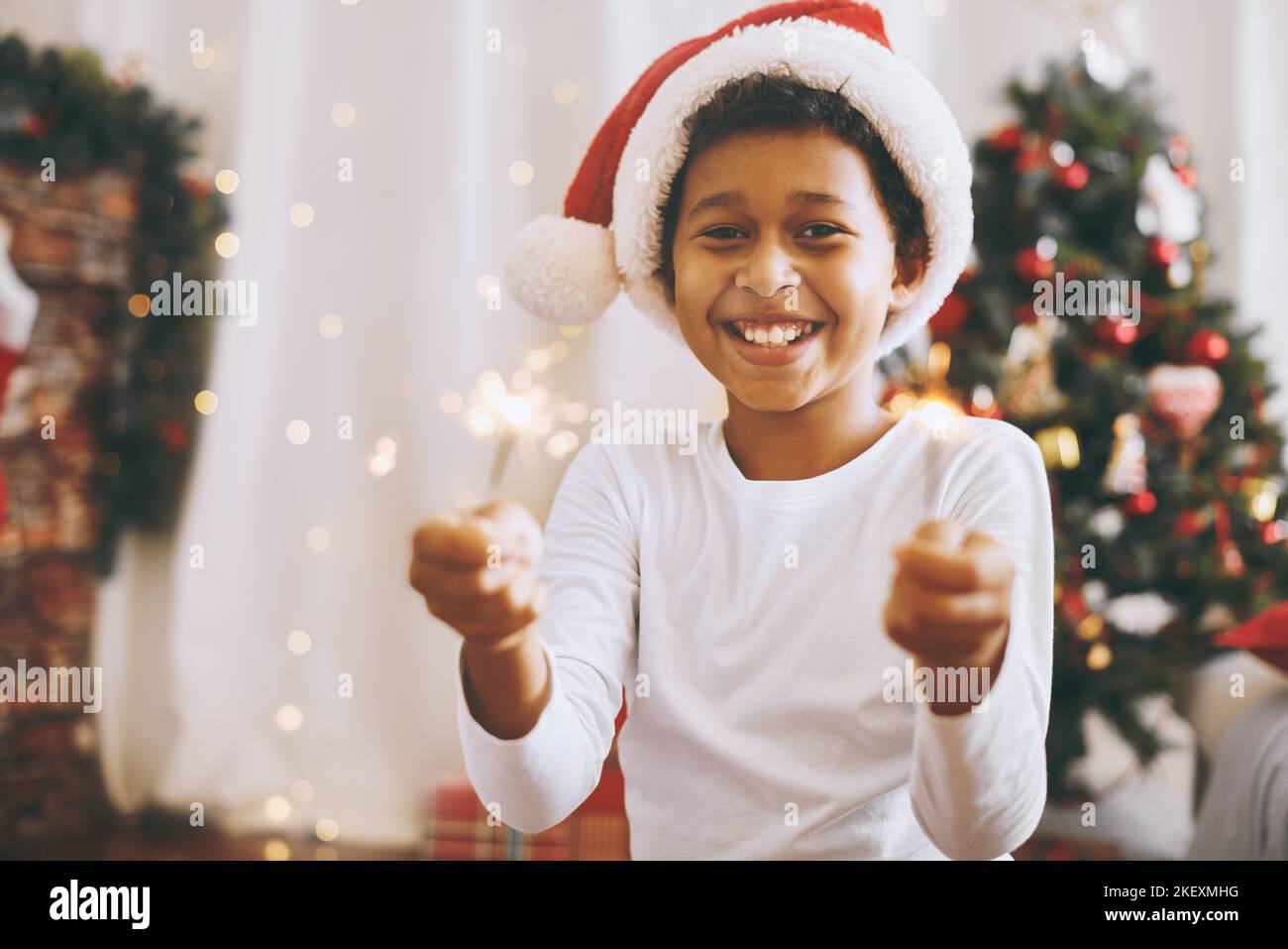 Adorabile colore della pelle scura del ragazzo in costume festivo divertente con le luci bengalesi Foto Stock