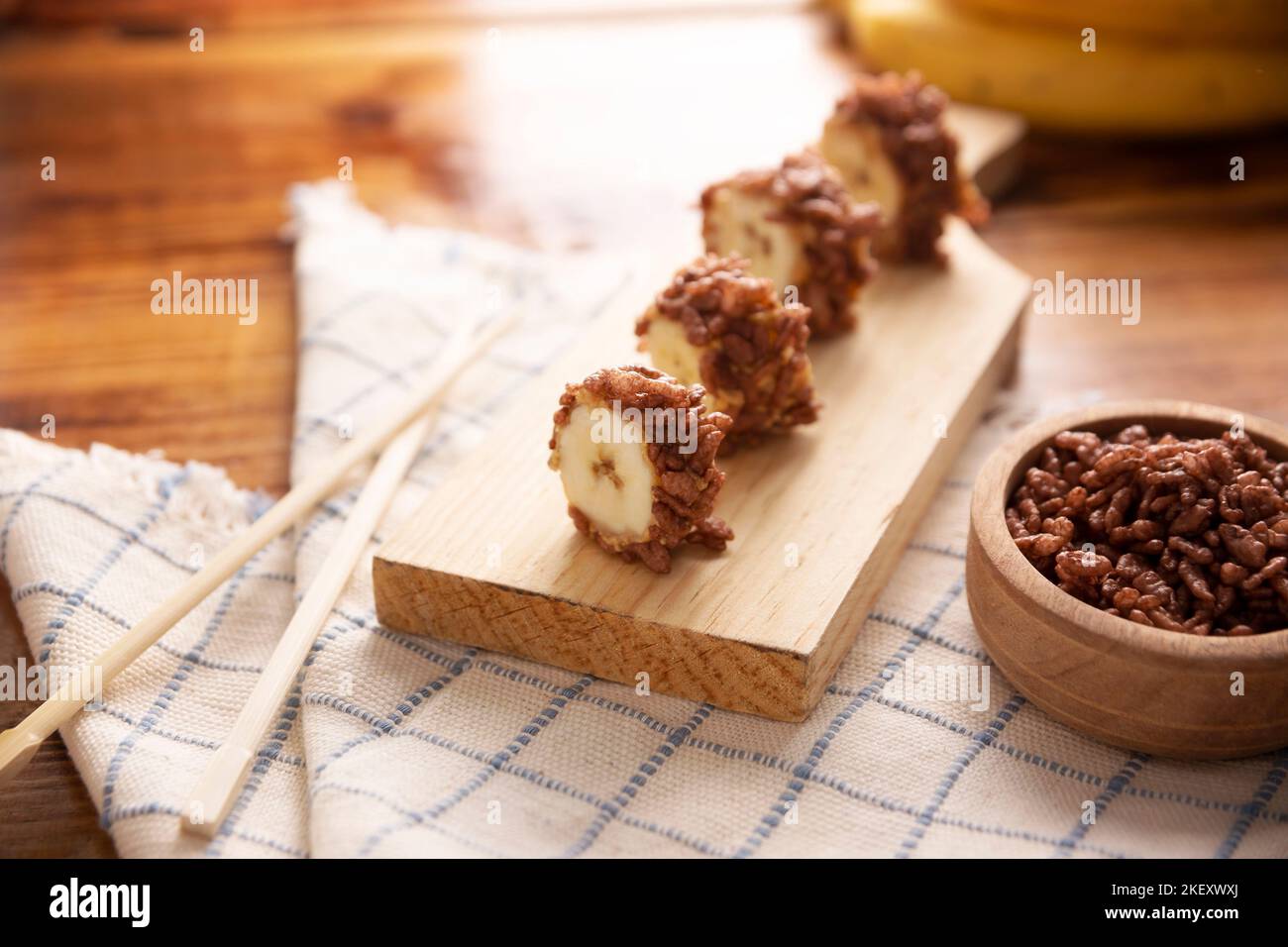 Panini dolci sushi alla banana con caramello, burro di arachidi e riso soffiato al cioccolato. Divertente e facile spuntino fatto in casa per bambini e adulti. Foto Stock