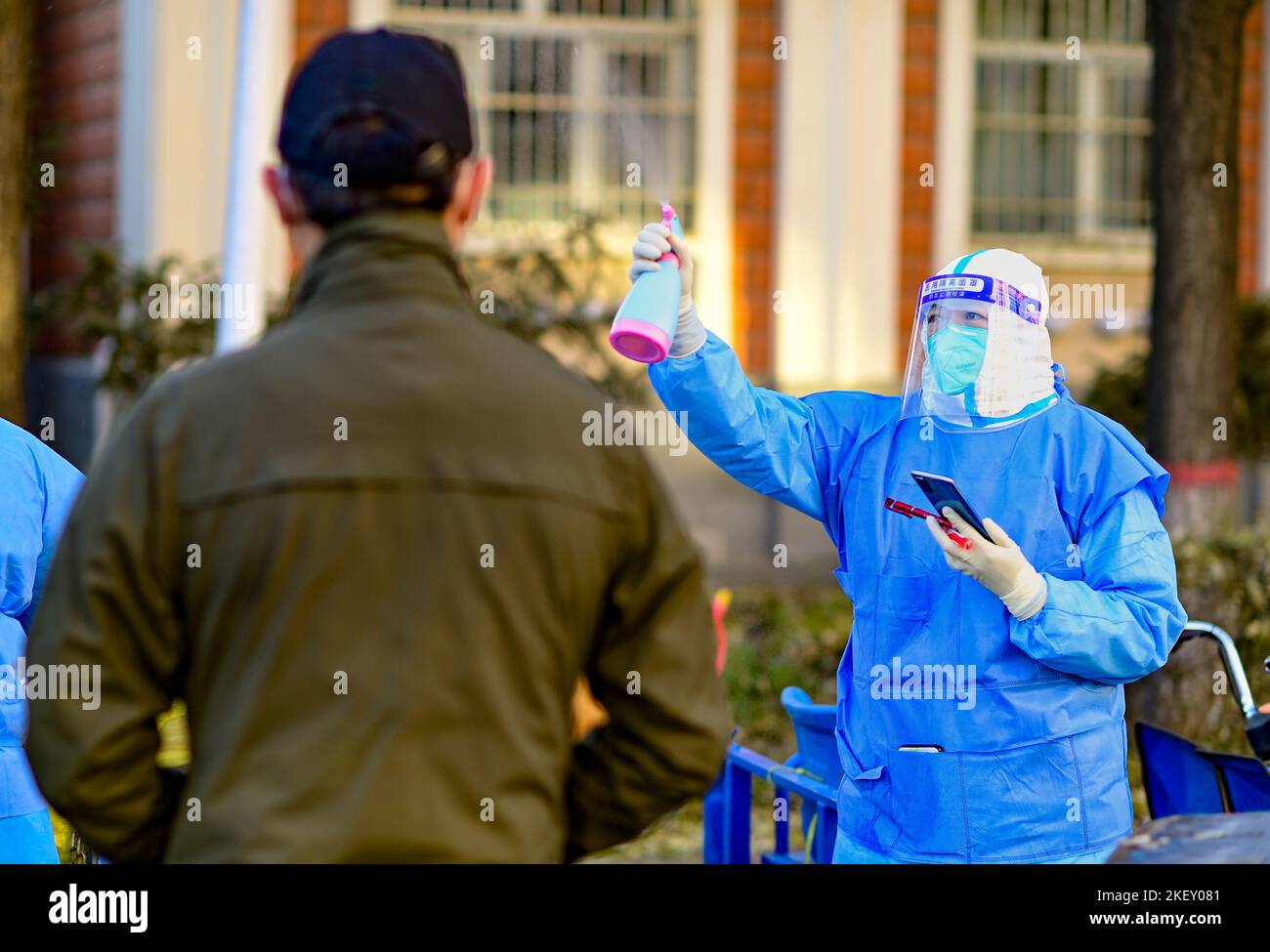 HOHHOT, CINA - 15 NOVEMBRE 2022 - Un lavoratore di comunità disinfetta l'ambiente di un sito di screening di acidi nucleici in una comunità residenziale a Hohho Foto Stock