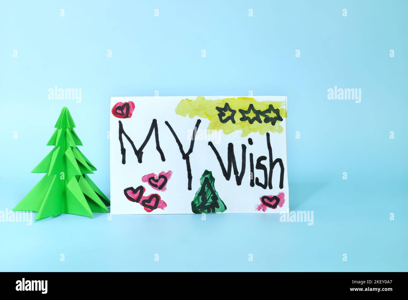 Natale lettera desiderio da capretto concetto. Primo piano di un disegno scritto accanto ad un albero di natale. Foto Stock