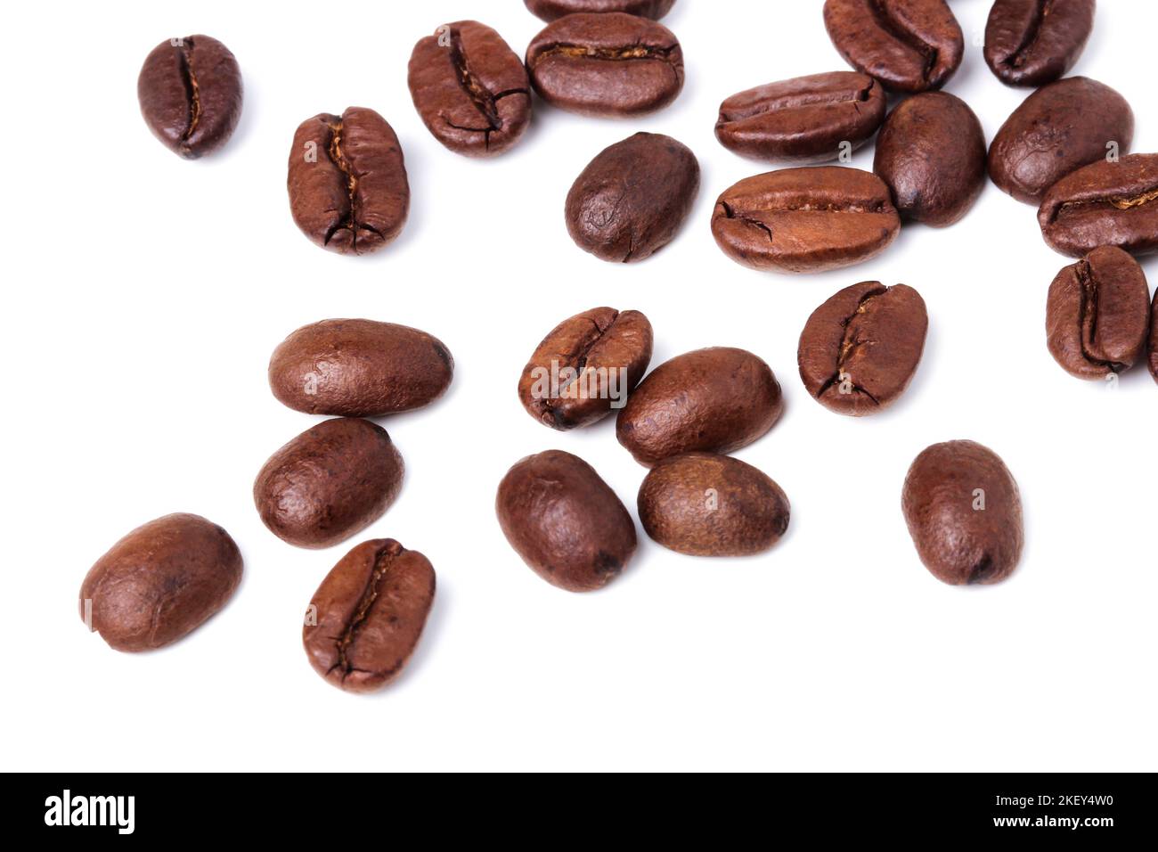 I chicchi di caffè sono sparsi su uno sfondo bianco Foto Stock