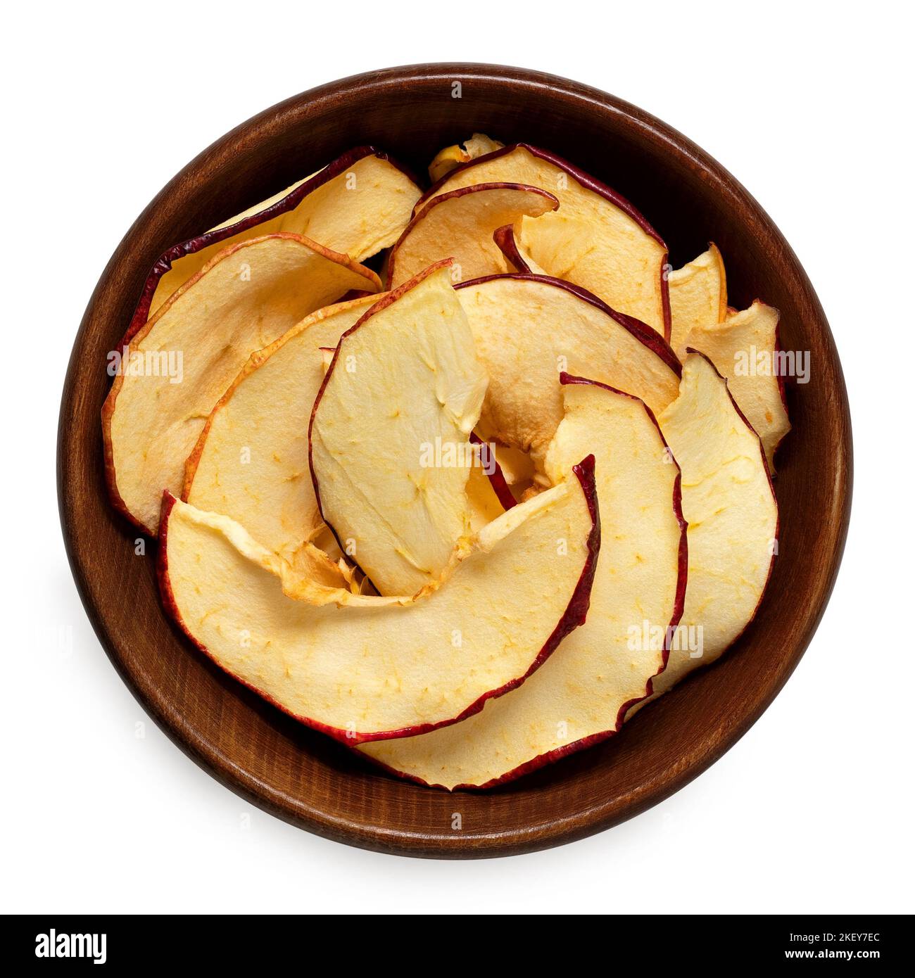 Fette di mela essiccate in una ciotola di legno marrone isolata su bianco. Vista dall'alto. Foto Stock