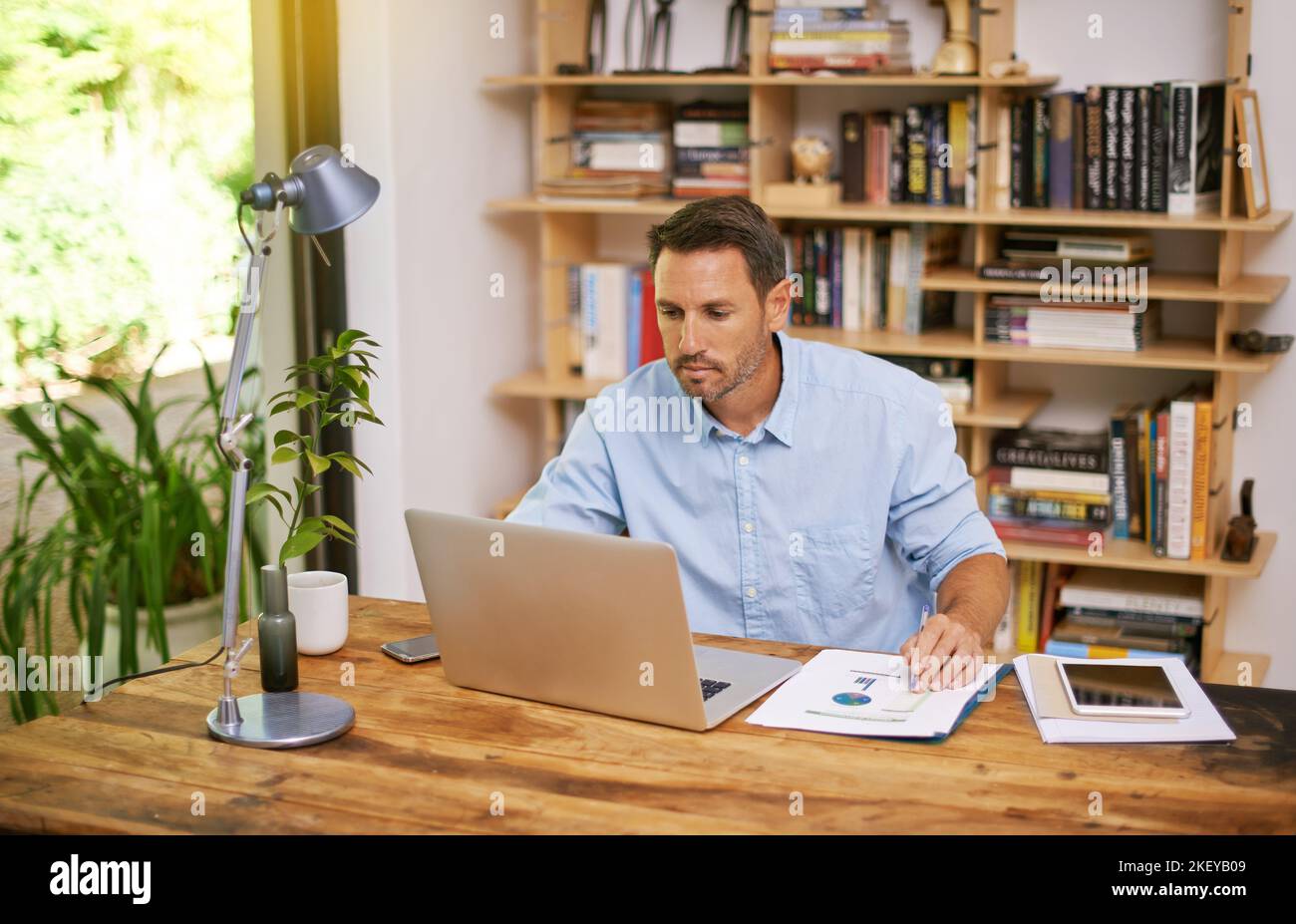 I documenti importanti devono essere controllati e riconsegnati, un giovane che lavora da casa. Foto Stock