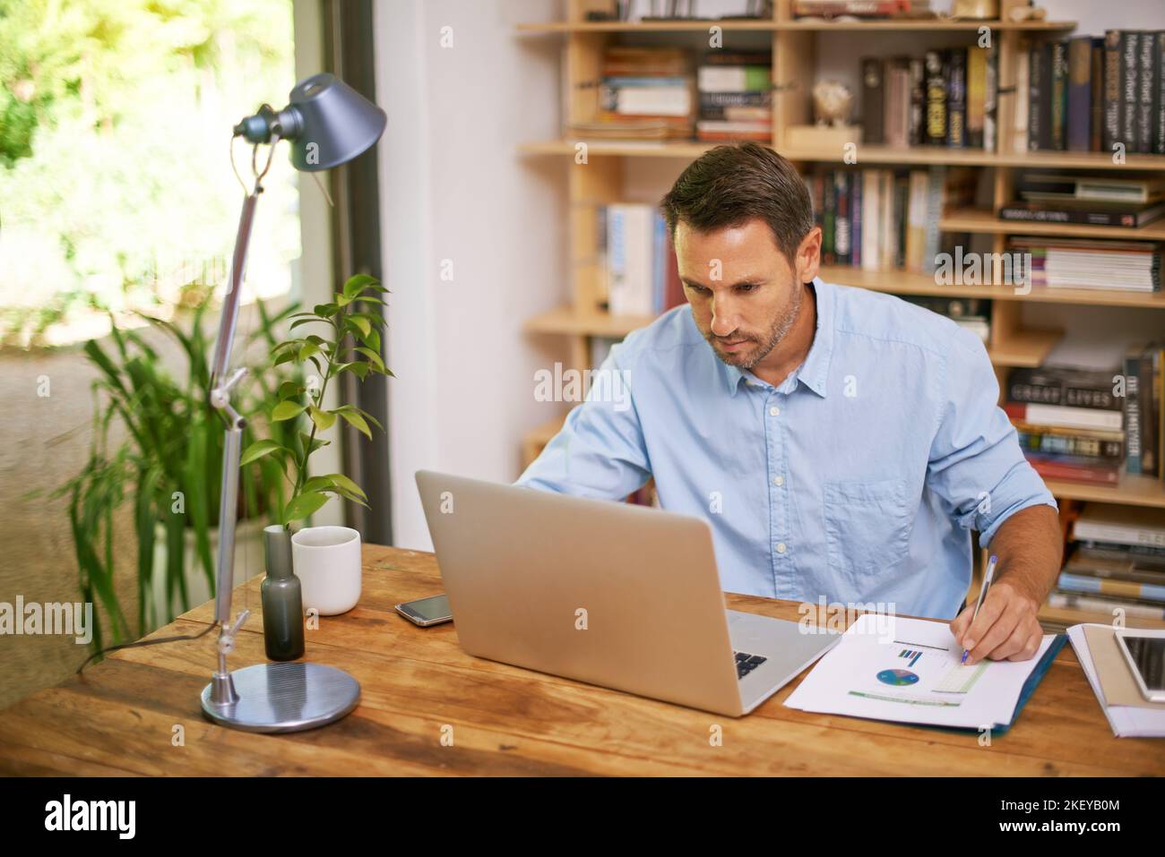 Il lavoro di ufficio è la base di un business di successo, un giovane che lavora da casa. Foto Stock