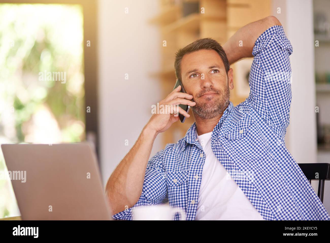 Rimanere in contatto con i suoi clienti, un giovane che lavora da casa. Foto Stock